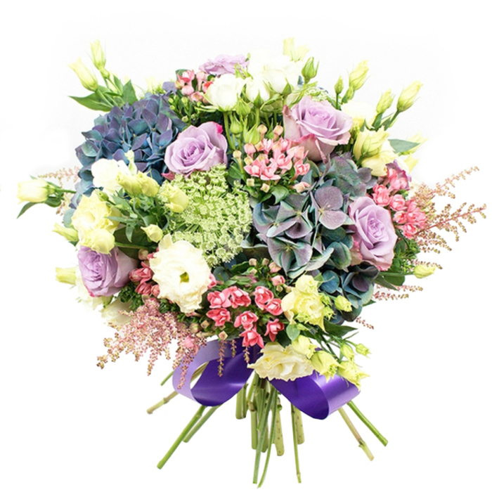 This luxurious bouquet, arranged by Cubitt Town Flowers, unfurls in layers of vivid colour and captivating texture-echoing the dynamic landscape of the Isle of Dogs. Large, cloud-like clusters of hydrangea in indigo, teal, and violet form a striking anchor, reminiscent of the tranquil riverfronts and green spaces nearby. Nestled close are lush lilac and creamy white roses, their elegant, spiraling petals adding a note of romantic sophistication and carrying the gentle promise of new beginnings. Tucked within, white ranunculus provide a plush, multi-petaled contrast, softening the overall structure, while upright eustoma (lisianthus) buds and blossoms in pale yellow-green add refreshing lightness and subtle height. Throughout the bouquet, vivid accents of fuchsia and pale blush filler flowers sparkle with energy and personality, enhanced by the whimsical softness of feathery astilbe at the outer edges. Delicate, almost see-through clusters of Ammi Majus or similar lacy filler bring fine, intricate detail, giving the whole arrangement a light, airy feel. A halo of glossy, deep green foliage grounds the bouquet, framing every bloom with freshness and vitality. Bound together at the base, the stems are finished with a luxurious, wide royal purple satin ribbon-reflecting Cubitt Town's blend of modern vibrancy and historic elegance. Perfect for centrepieces, milestone celebrations, or as a thoughtful gift, this bouquet embodies both exceptional craftsmanship and the welcoming spirit of Cubitt Town.